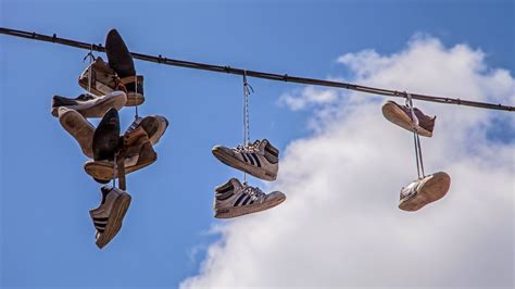 shoes hanging in trees meaning|shoes hanging from power line.